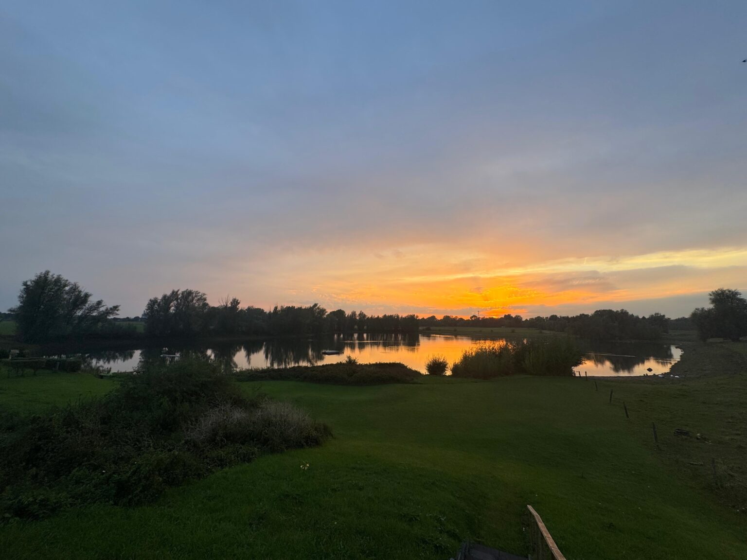 Zonsondergang boven het water van Visvijver De Kromme Hengel.